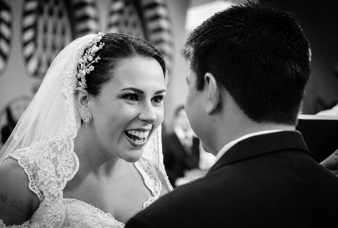 Noiva sorrindo durante a cerimônia, em preto e branco