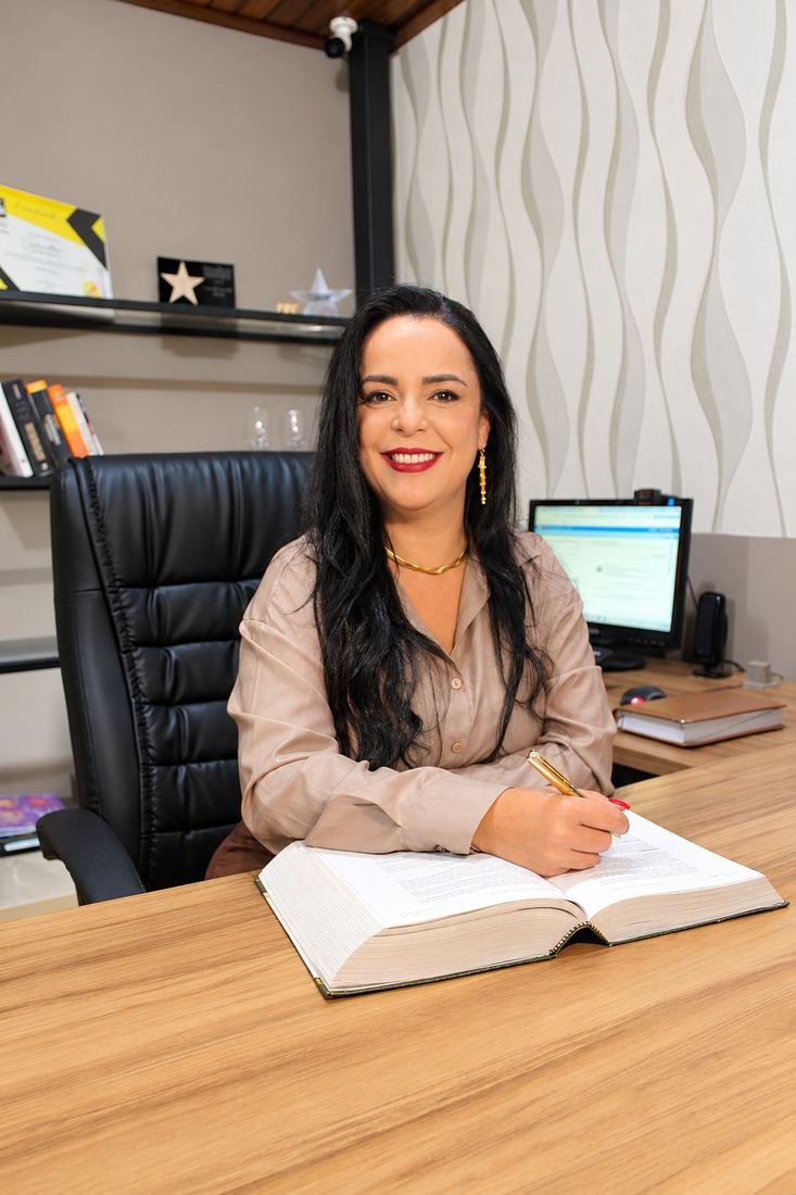 Retrato profissional de advogada com livro e caneta dourada